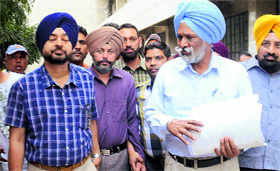 Tehsildar-cum-sub-registrar Arvinder Singh (sporting brown turban) before being produced in a court on Saturday.