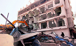 Municipal workers demolish an illegal building in the wake of the recent building collapse in Thane on Saturday
