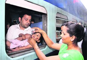 Saving lives: Health Department staff administer polio drop to a child at the city railway station in Jalandhar on Sunday