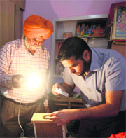 A fingerprint expert examines the site where the theft took place at Haibowal in Ludhiana on Sunday. 