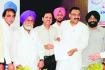 Pawan Dewan, president of the District Congress Committee, Ludhiana, hands over a cheque to Dr Manoj Sobti, president of the Indian Medical Association, Punjab.