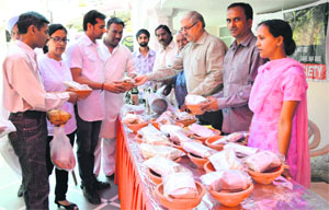 Office-bearers of the CAPE-India distribute earthen bowls among residents at the Adinath Jain temple in Ludhiana on Sunday.