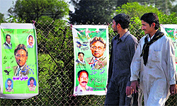 People look at posters of Pervez Musharraf near Islamabad on Sunday. Musharraf was given approval to run for Parliament in Chitral after being rejected in two other constituencies