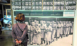 A visitor looks at pictures of Holocaust victims at the Yad Vashem's Holocaust History Museum in Jerusalem on Sunday. Starting Sunday, Israel marks the annual memorial day commemorating the 6 million Jews killed by the Nazis in the Holocaust during World War II