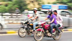 Men ride a TVS Victor motorbike (R) in Guwahati. TVS Motor Co and BMW AG's motorcycle division, BMW Motorrad, announced a long-awaited cooperation agreement on Monday in a deal that see the companies jointly develop a new range of sub-500cc motorcycles as TVS looks to stem a slide in its market share.  Reuters