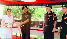 The GOC, Amogh Division, Major General NC Badhani, gives a computer to Manju Thakral, principal of Government High School, Asafwala.