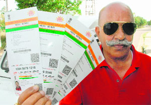 Davinder Mahajan, president of the Residents' Welfare Association, shows four e-Aadhaar cards bearing the address of his house in Panchkula on Monday.