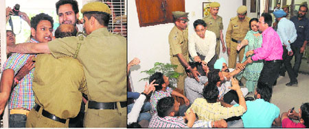 Members of the National Students' Union of India try to force their way into the Vice-Chancellor's office; and (right) security guards try to evict the protesters from the office at Panjab University in Chandigarh on Monday. 