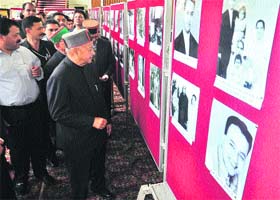Chief Minister Virbhadra Singh takes a look at photographs during an exhibition on the completion of his 30-year association with the HP Vidhan Sabha in Shimla on Monday