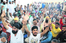 Members of the Jalandhar Autorickshaw Union protest outside the DTO's office in Jalandhar on Monday.