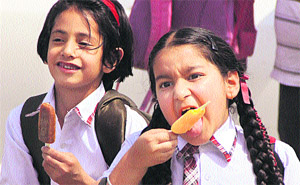 Two schoolgirls enjoy their first summer kulfi in Jalandhar on Monday.