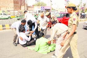 Passersby help a couple after their scooter was hit by a car near Hanuman Chowk in Bathinda on Tuesday