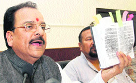 Ajay Bhatt, Leader of the Opposition in the state Assembly, shows a copy of the Constitution at a press conference in Dehradun on Tuesday. 