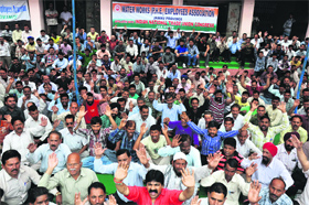 Members of the Water Works Employees Association protest outside the PHE office in Jammu on Tuesday.