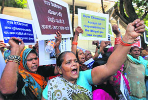 Survivors of Bhopal gas tragedy shout slogans during a protest for compensation outside the office of The Dow Chemical Company in Mumbai on Tuesday. 