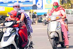 Commuters cover their faces while venturing out in Bathinda