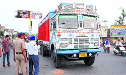 Policemen stand near the truck that was involved in a mishap on Wednesday in which a man was killed. A resident of Bhagu road, Malkit Singh died when his scooter was knocked down by the truck on Powerhouse road