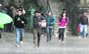 People try to escape a hailstorm in Shimla on Wednesday. 