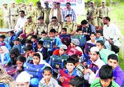 Police officials distributed school bags and books to students of remote villages in Rajouri on Wednesday. A Tribune photograph