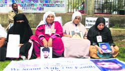 Relatives of missing persons hold banners during a sit-in organised by the Association of Disappeared Persons in Srinagar. Tribune photo: Yawar Kabli