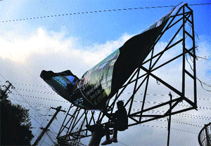 A worker tries to fix a hoarding on a windy day in Ludhiana.