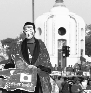 A member of the "red shirt" movement at a gathering near the Democracy Monument where supporters of former PM Thaksin Shinawatra marked the third anniversary of bloody clashes with Thai security forces in Bangkok on Wednesday.  
