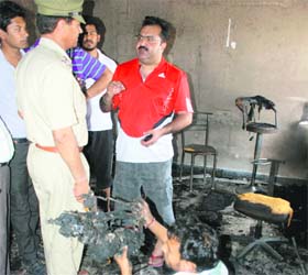 The police inspects the shop that was set afire in Sector 16, Panchkula, on Thursday