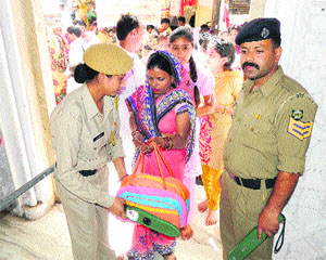 Police personnel frisk pilgrims at the gate of the Bajjreshwari temple on the first day of the Chaitra Navratras in Kangra on Thursday. 