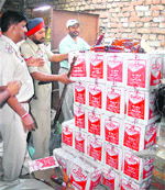 Policemen stand beside a huge stock of liquor at Qazi Mandi in Jalandhar on Thursday.