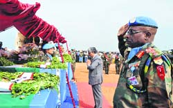 A United Nations peacekeeper and Indias Ambassador Parmod Bajaj (centre) pay tributes to the five UN Indian peacekeepers killed during an ambush, in Juba, South Sudan, on Wednesday. The coffins of the slain soldiers were later flown back to India.  AFP