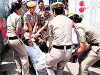 Women constables lift a protester in the city on Friday. They were demanding the withdrawal of alleged false case against the arrested farmers in the ASI murder case