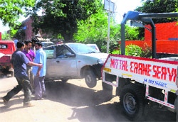 Workers tow away a car during an anti-encroachments drive at the Sector 38 motor market in Chandigarh on Friday. 