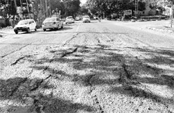 The road separating Phase 3B1 and Phase 3A in a bad shape; and a damaged road in Phase IX, Mohali. 