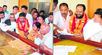 BJP candidate Manoj Garg and (right) Congress candidate Swami Rishiwaranand submit their nomination papers for the post of Mayor at the district election office in Haridwar on Friday. 