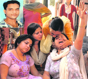 Family members of Vijay Kumar (inset), who committed suicide, being consoled by relatives in Jalandhar on Friday.