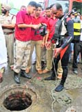 A deep diver of the National Disaster Response Force prepares for a dive into the manhole opposite the Government Rajindra College to rescue a worker trapped inside. Photo: Bhupinder Dhillo