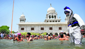 Devotees take a dip in the sarovar at Gurdwara Gau Ghat on the occasion of Baisakhi in Ludhiana on Saturday.