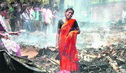 A woman cries in front of her gutted shanty after a major fire in the veterinary area in Patna on Saturday.