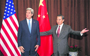 China's Foreign Minister Wang Yi (R) gestures next to United States Secretary of State John Kerry at the Chinese Ministry of Foreign Affairs in Beijing on Saturday. 