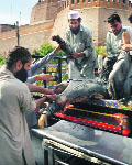 Hospital workers carry the body of a victim killed by a bomb blast at the Mattani Bazaar, on the outskirts of Peshawar, on Saturday. 