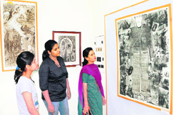 Visitors have a look at a painting during an exhibition at the Thakur Singh Art Gallery in Amritsar on Sunday.