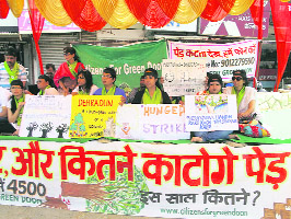 Activists of Citizens for Green Doon stage a dharna against the felling of trees in Dehradun on Sunday.