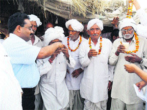 DC Pankaj Aggarwal offers juice to one of the villagers to end their 16-month-old dharna at Chidana village on Saturday. 