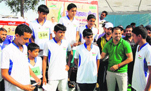 Boxer Akhil Kumar shares a light moment with young athletes at the prize distribution ceremony of the marathon at Cheeka on Sunday. 