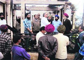 MLA, Ramban, Ashok Kumar looks at the ruins of the gutted building in Champa