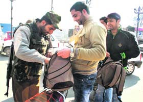 Checking drive: A policeman frisks a youth in Srinagar on Sunday