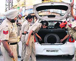 Police perssonel check a car during a naka in Patiala on Sunday