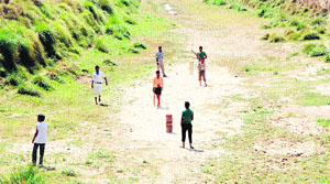 In the absence of a proper ground, boys play cricket in a dry drain near Khem Karan border.