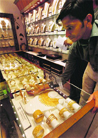 A jeweller arranges gold ornaments at his shop in Mumbai. Gold futures dropped by nearly 3 per cent to hit the lowest level on Monday