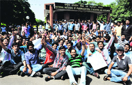 Students protest in front of the National Institute of Pharmaceutical Education and Research in Mohali on Monday. 